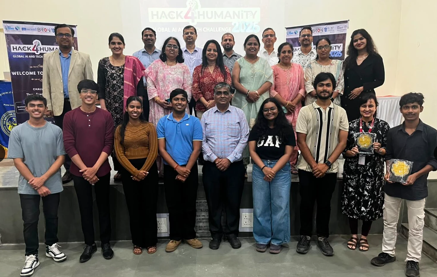 Students, faculty and guests on stage in front of the Hack4Humanity 2026 Global AI and Tech Challenge banners