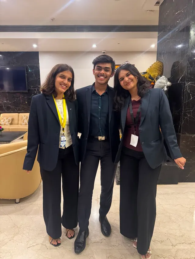 Three people in blazers standing in a hotel lobby