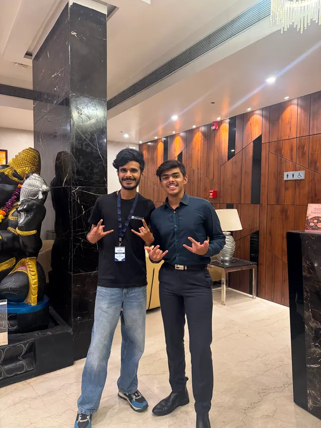 Two people posing, one wearing an IEEE Pune Section t-shirt and a volunteer badge