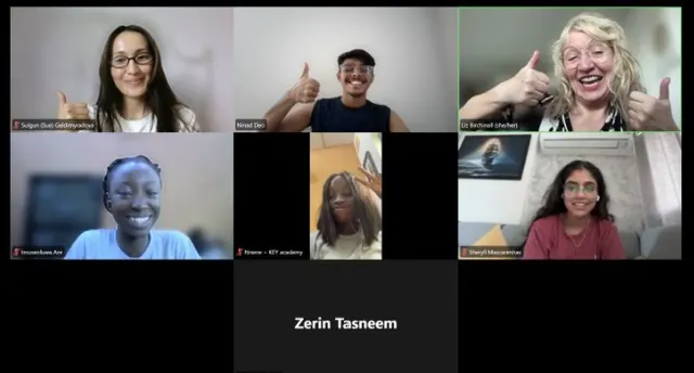 A video call with participants smiling and giving a thumbs up